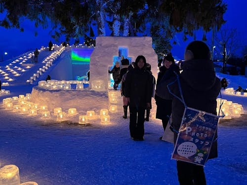 アイスキャンドルフェスティバルにて、来場者の写真撮影を行う中学生