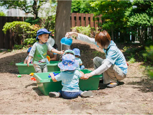 園庭で水遊び。大人が決めた「一斉遊び」はせず子どもが思い思いに遊びます