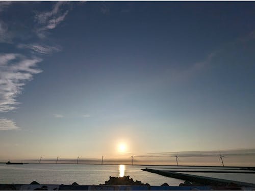 港湾区域の洋上風力発電と夕暮れ