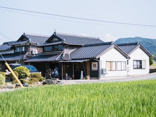 田園地帯に佇む民宿スペースを併設する古民家カフェ「NATAJIMA-BASE」