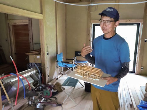 家の模型を持ちながら話す川端さん