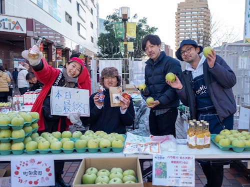 地元農家や行政と連携して首都圏物産イベントで出展サポートする隊員(写真左側2名)