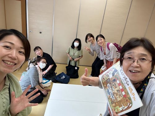 地域団体と一緒に本の読み聞かせをとおして子育て支援活動に取り組む隊員（写真左）