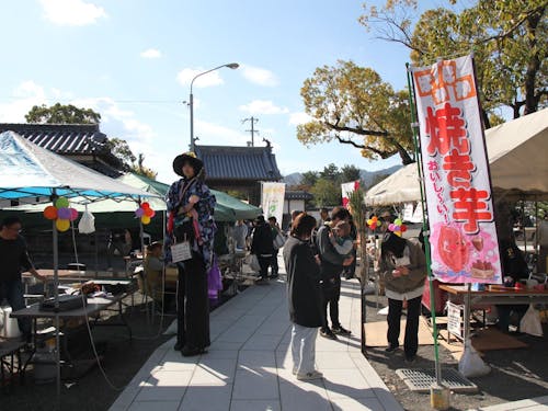 境内に屋台が並んでいる風景です!なにやら背が高い人が?!