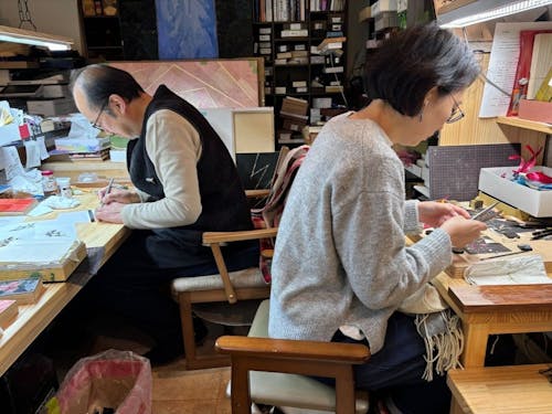 店舗で麦わら細工を作る神谷さんと地域おこし協力隊員のいつもの風景