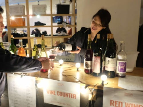 お客さんへ優しく語りかけながらワインを注ぐ酒本さん