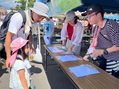 うどんまつりでの様子。マップ配りやアンケートなど積極的にお客さんと交流