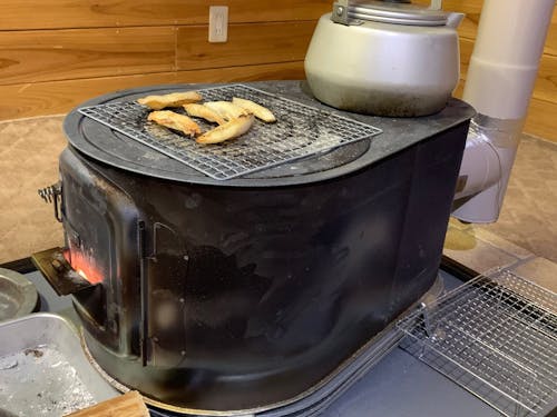 干した魚を薪ストーブで炙っておやつに。体も心も温まる風景が暮らしの中にあります♨