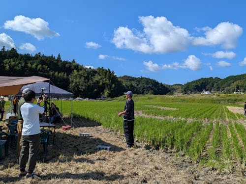 後ろに広がるのは森本さんが稲作に励む田んぼ