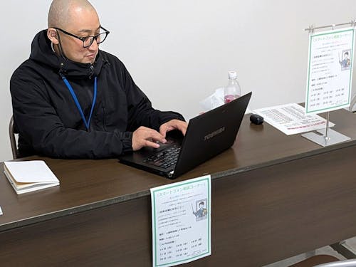 役場内に新設された「スマホ相談コーナー」で相談を受け付ける先輩隊員の石田さん