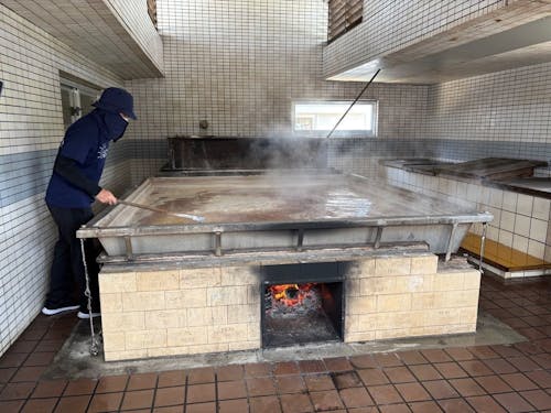 塩をかき混ぜながら煮込む作業