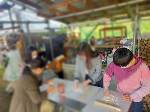 協力して生地を成形し、ピザを作っていきます