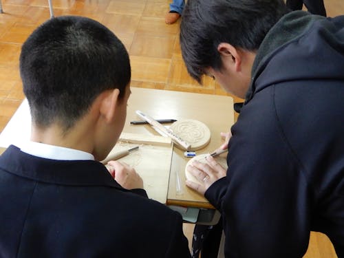 アイヌ文化Ⅰ「木彫」の授業の様子（※講師は地元のアイヌ文化伝承者の方々）