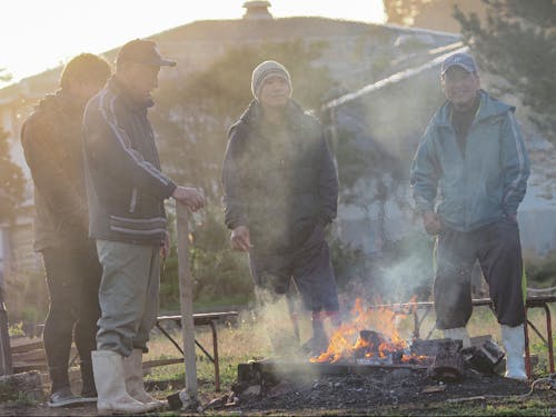 午前7時。いつもの場所で焚火を囲む萩市大井浦の漁師さんたち。ここが情報交換の場だ。