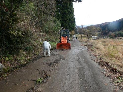 雪解け後に道路に流れ出てきた泥を清掃する様子