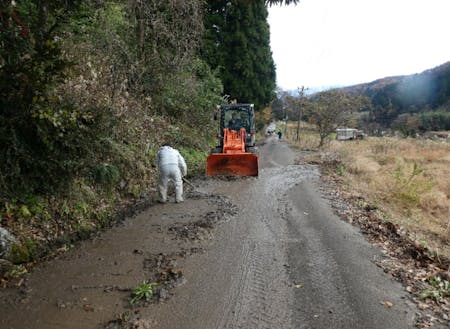 雪解け後に道路に流れ出てきた泥を清掃する様子