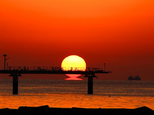 水平線に沈む太陽がだるまのような形にみえる「だるま夕日」(室積海岸・光市)