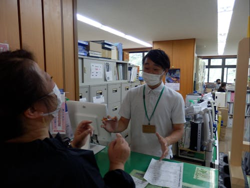 窓口に来られた村民さんに笑顔で対応中