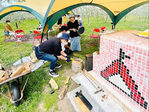 りんご園地で様々な遊びをつくっている住民団体「ふじさきAPPLEミアミューズメント」によるりんごのお花見会。りんごの花に囲まれながら手作りアップルパイなどを提供。