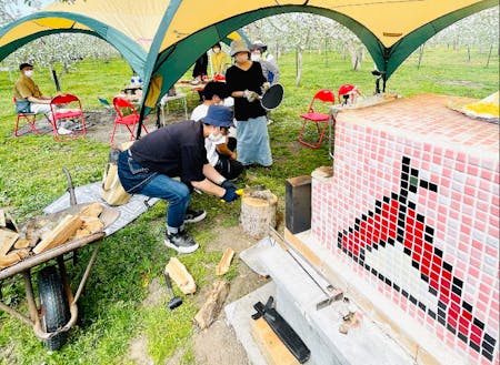 りんご園地で様々な遊びをつくっている住民団体「ふじさきAPPLEミアミューズメント」によるりんごのお花見会。りんごの花に囲まれながら手作りアップルパイなどを提供。