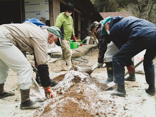 土間に使う赤土と消石灰を混ぜるの図。集落の皆さん、工務店も顔負けの大活躍!