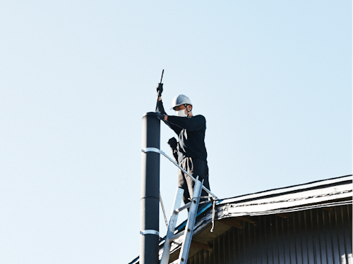 煙突掃除の様子。お客様の薪ストーブライフを支える大事な仕事です。