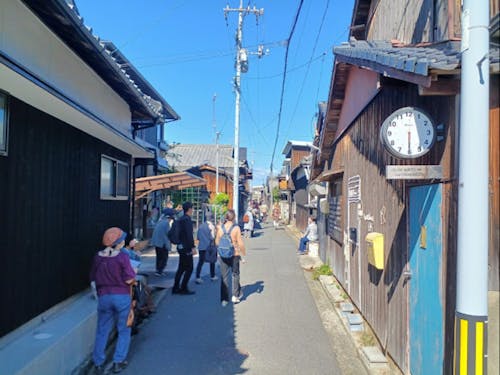 本村（ほんむら）の町並みを散策する観光客。