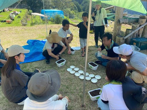 種まきのコツを教わっている様子