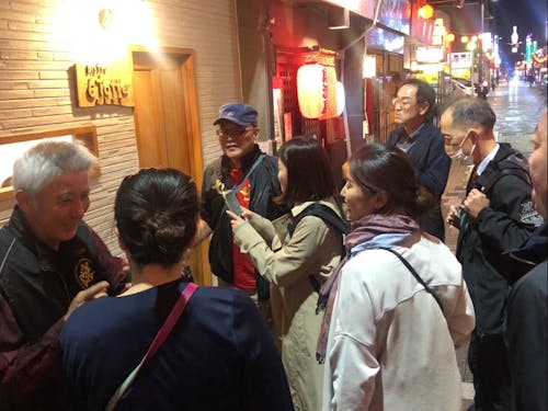 八戸せんべい汁研究所のスタッフが横丁を案内する様子。八戸のことなんでも知ってます