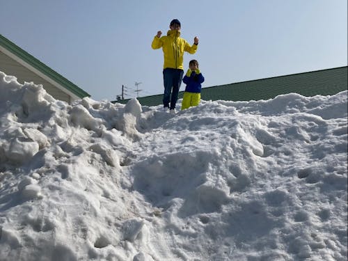 岩下 直人:大手メーカーの研究員を経て、兵庫県から家族4人で下川町へ。除雪でできた大きな雪山で、娘さんと雪遊びしている様子。