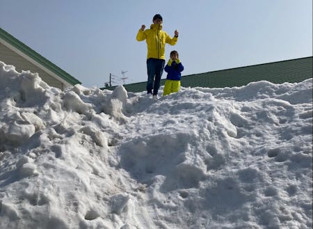 岩下　直人：大手メーカーの研究員を経て、兵庫県から家族4人で下川町へ。除雪でできた大きな雪山で、娘さんと雪遊びしている様子。