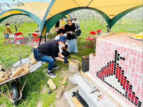 りんご園地で様々な遊びをつくっている住民団体「ふじさきAPPLEアミューズメント」によるりんごのお花見会。りんごの花に囲まれながら手作りアップルパイなどを提供。