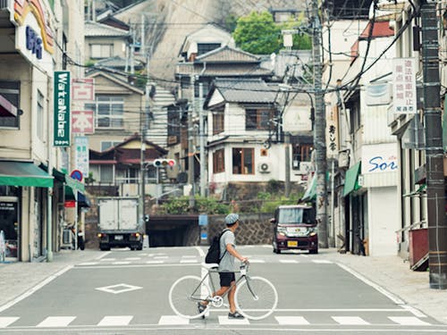 市街地。駅から続く商店街、線路の向こうに続く坂道。
