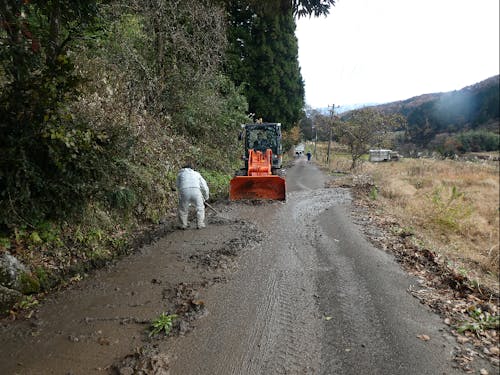 雪解け後に道路に流れ出てきた泥を清掃する様子