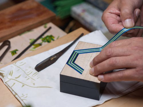 自然由来の糊などを使い、色染めした麦を貼り付けます。