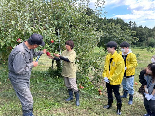 地域交流型研修(農家さんとリンゴ園にて)