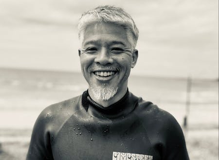 日本海でサーフィンを楽しむ田村さん。見た目からして公務員っぽくないんですけど。