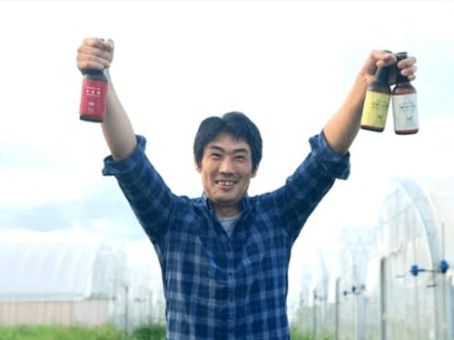 クラフトビールを掲げる三島さん