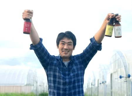 クラフトビールを掲げる三島さん