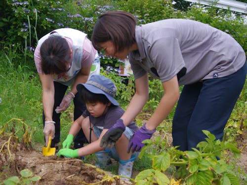 地域の子どもたちと一緒に、野菜や花の栽培に取り組む支援員