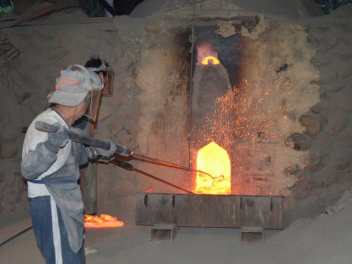 炭材の窯出し作業をする職人たち。