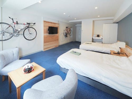 ゆったり広々とした客室。テレビボード・ヘッドボードは村産材を使用。全室サイクリングラック完備。