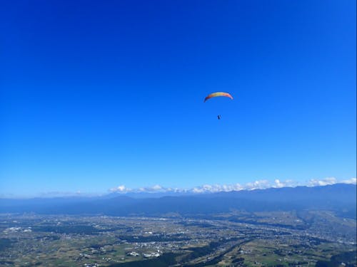 二つのアルプスに囲まれた谷を飛ぶパラグライダー