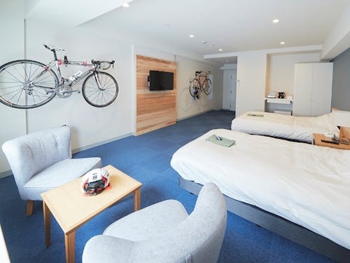 ゆったり広々とした客室。テレビボード・ヘッドボードは村産材を使用。全室サイクリングラック完備。