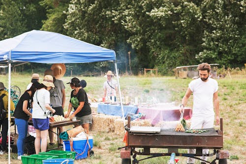 (過去の体験例1) 地元のファームに行って、野菜を収穫した後は、そのままみんなでクッキング。藁を椅子にして、外ごはん。地元の人と話をしながら、自分たちの手で作るファームトゥテーブル体験です。(写真撮影:島崎征弘)