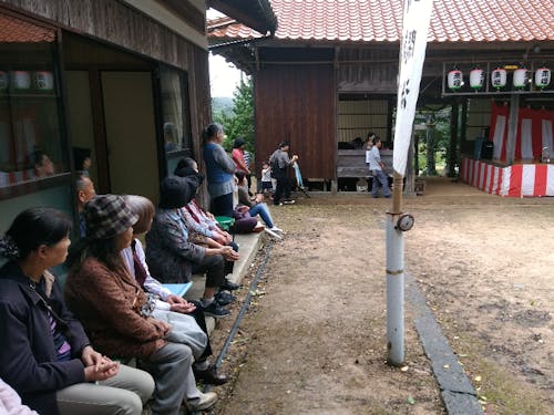 例年なら、こうして地域のみんなが神楽(右が舞殿)を楽しみます