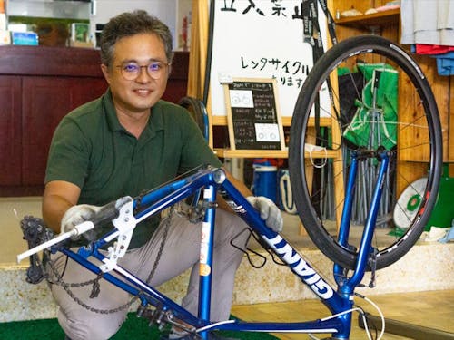 経営するホテルのロビーで、レンタサイクル「島のサイクルズ。」を営む町田さん。