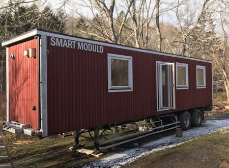 冬に設置した移動可能な木造建築”Smart Modulo”。宿泊や飲食もできるテレワーク拠点として利用可能。ここに太陽光発電システムやウッドデッキ等を整備していく。断熱がしっかりとしていて、冬の森の中でも快適に過ごすことができた。