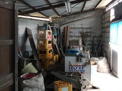 自転車やさんだった場所は物置に。手前の木の棚の中には当時の工具や部品が並んでいた。