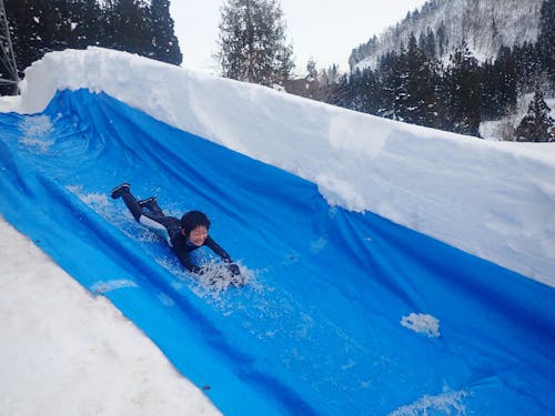 テンションマックス!寒くなったら、お湯のプールに浸かりながら、繰り返し挑む子どもたち。(スノーウォータースライダー)